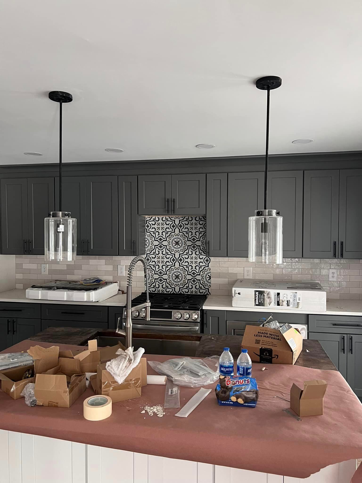 a kitchen with black cabinets and white counter tops is being remodeled .