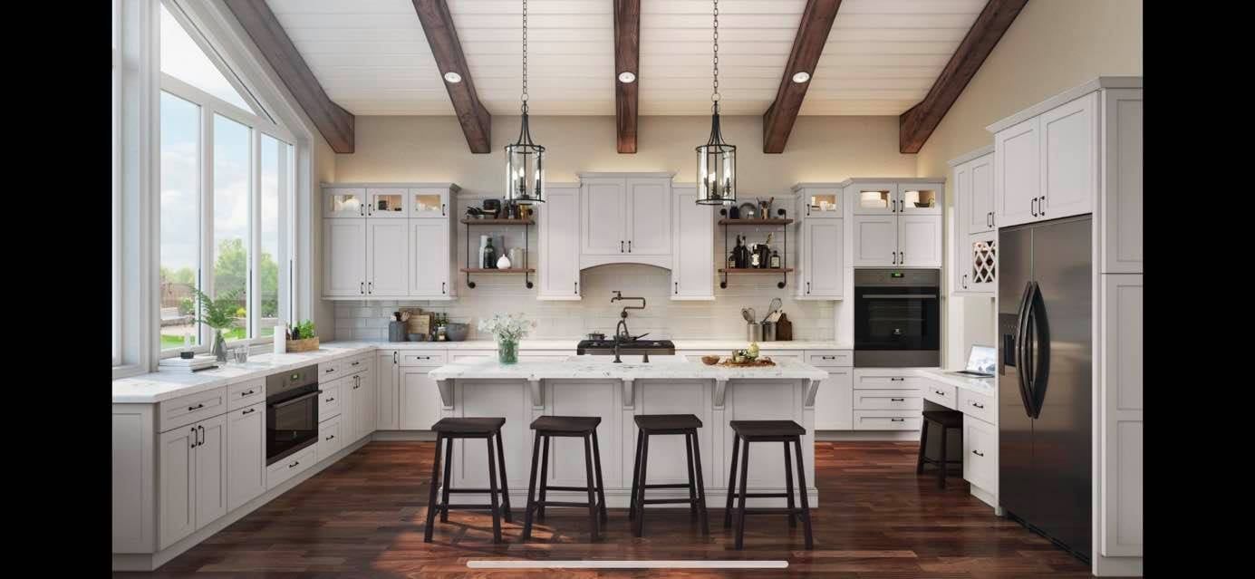a kitchen with white cabinets , stainless steel appliances , hardwood floors and a large island .