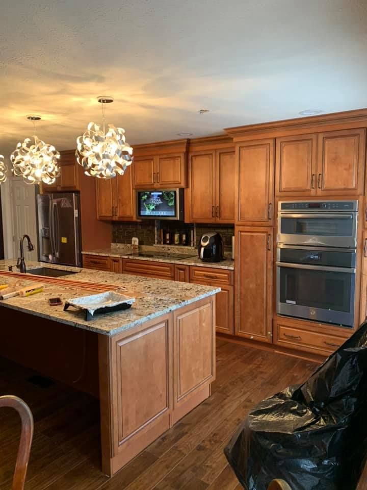 a kitchen with wooden cabinets , granite counter tops , stainless steel appliances and a large island .
