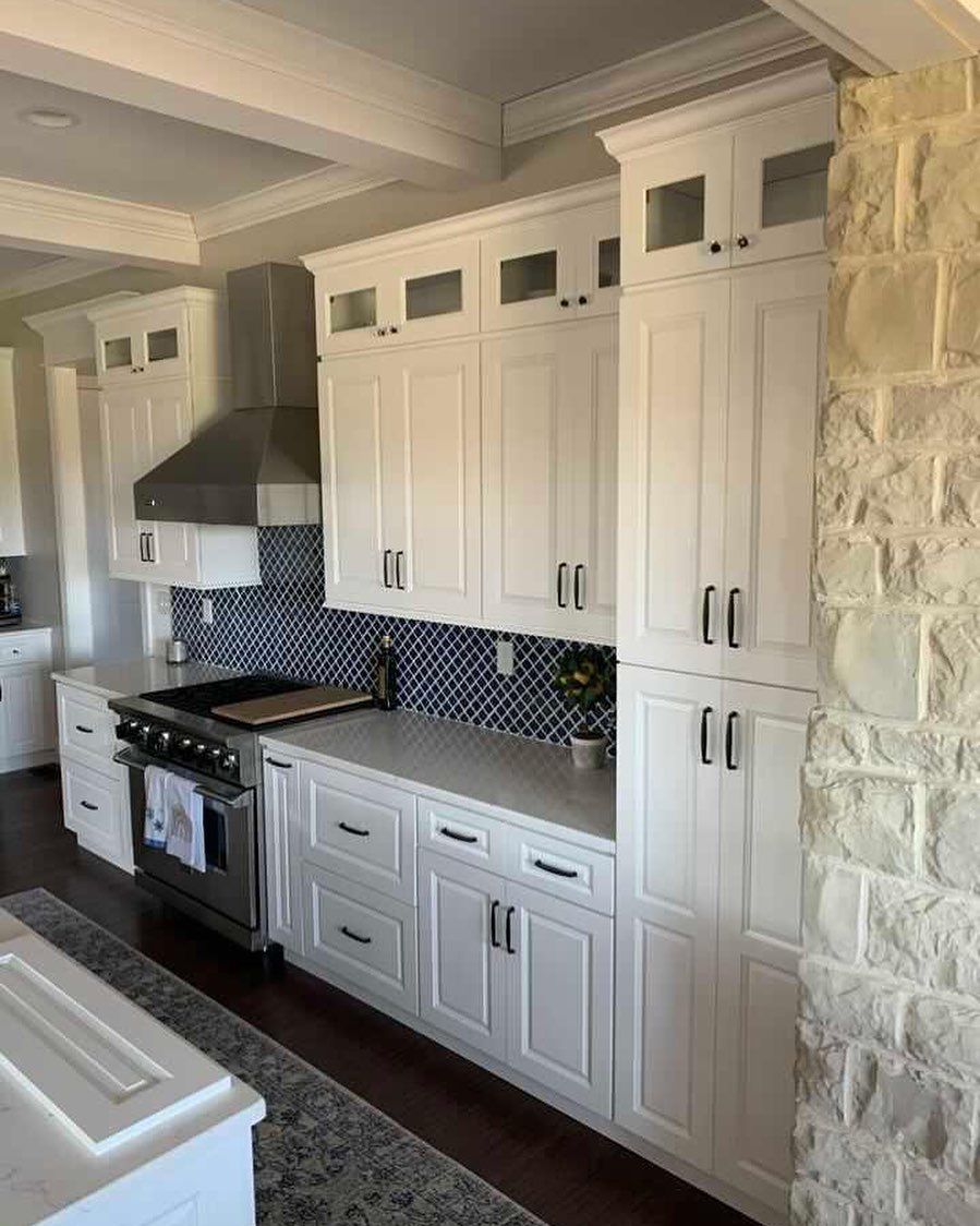 a kitchen with white cabinets and stainless steel appliances .