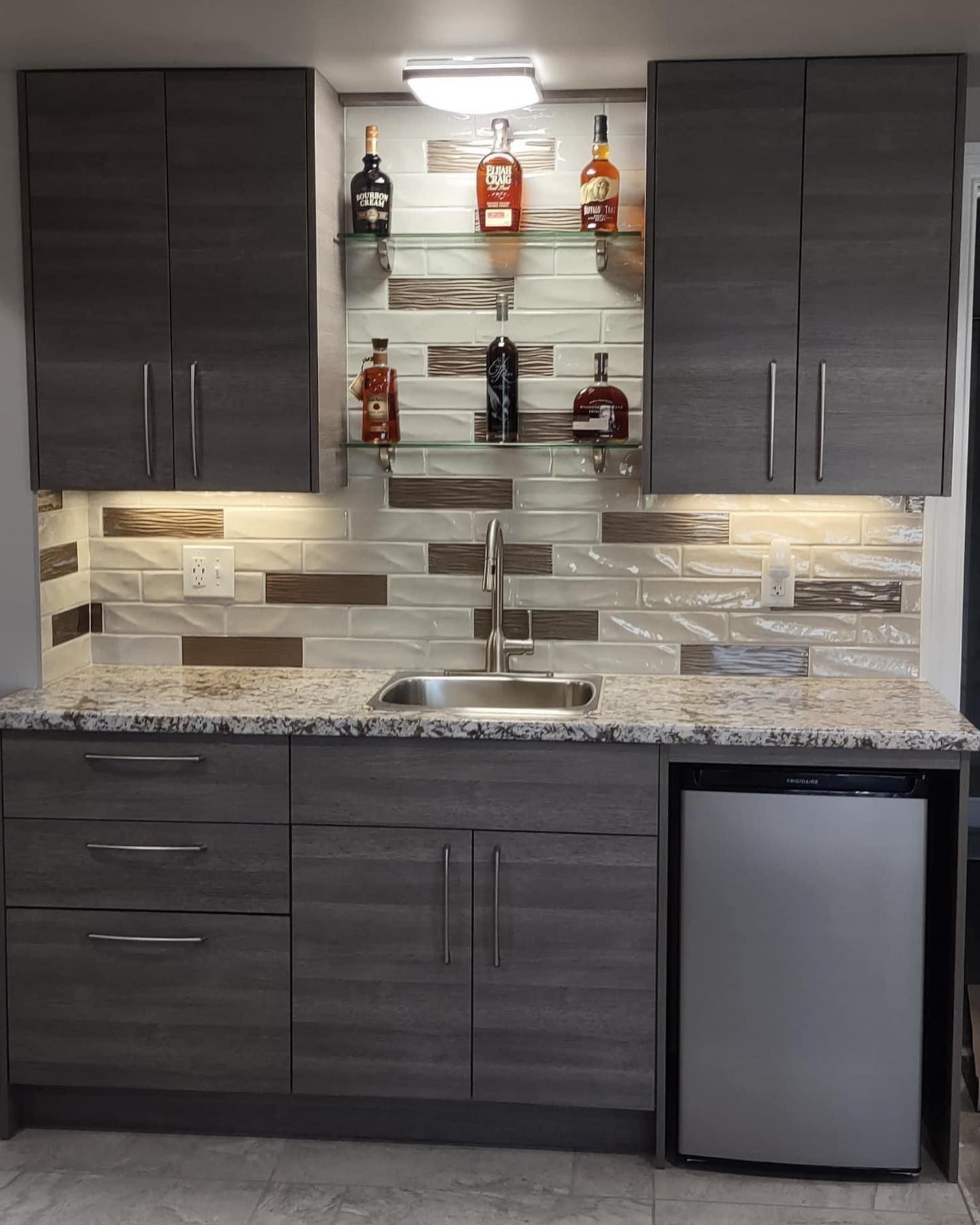 a kitchen with a sink and bottles on shelves