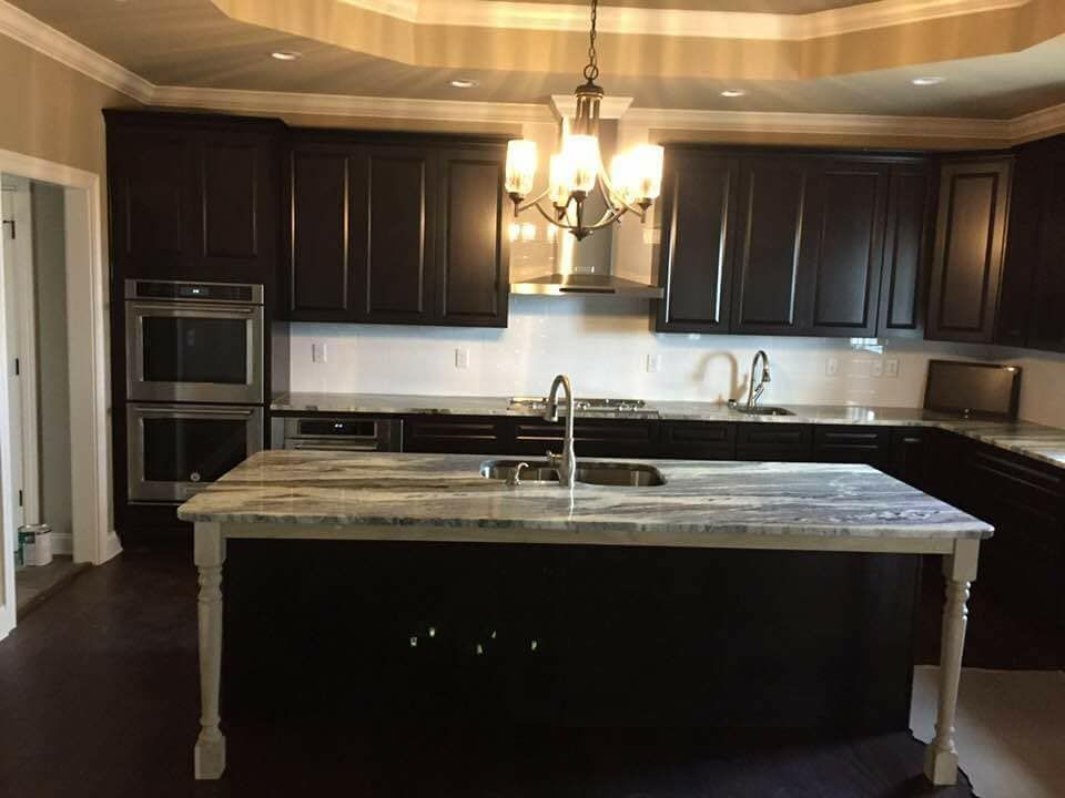 a kitchen with dark cabinets and a large island