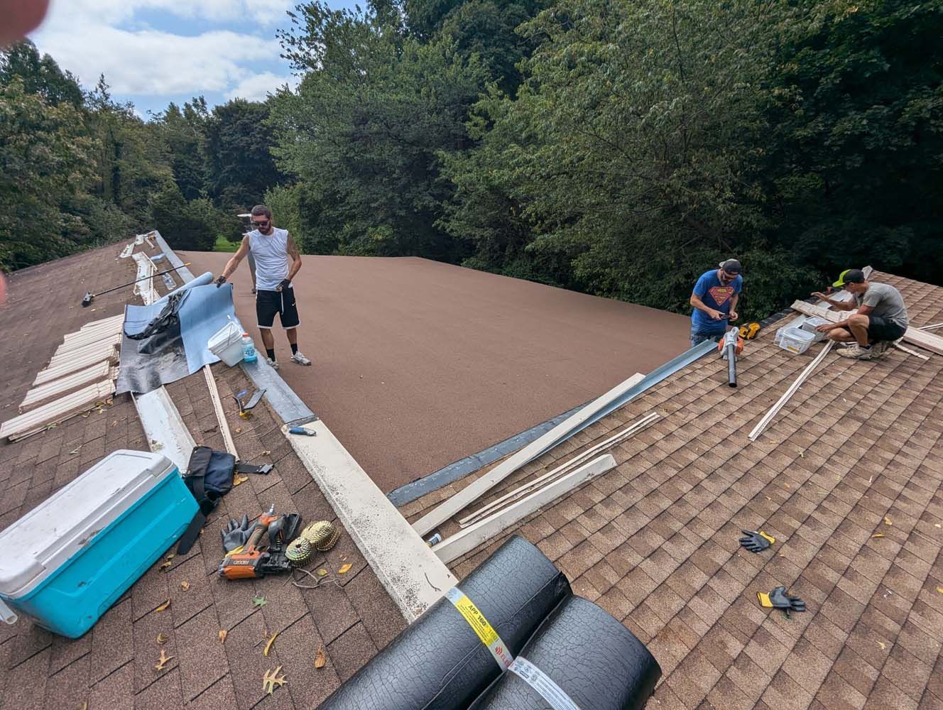 Roofers working on a roof, preparing for new shingles.