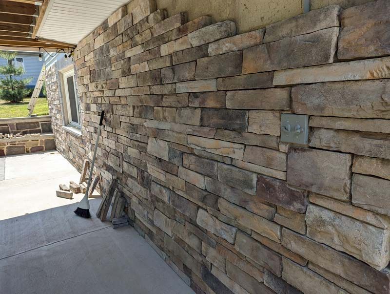 Exterior wall under construction with stacked stone veneer.