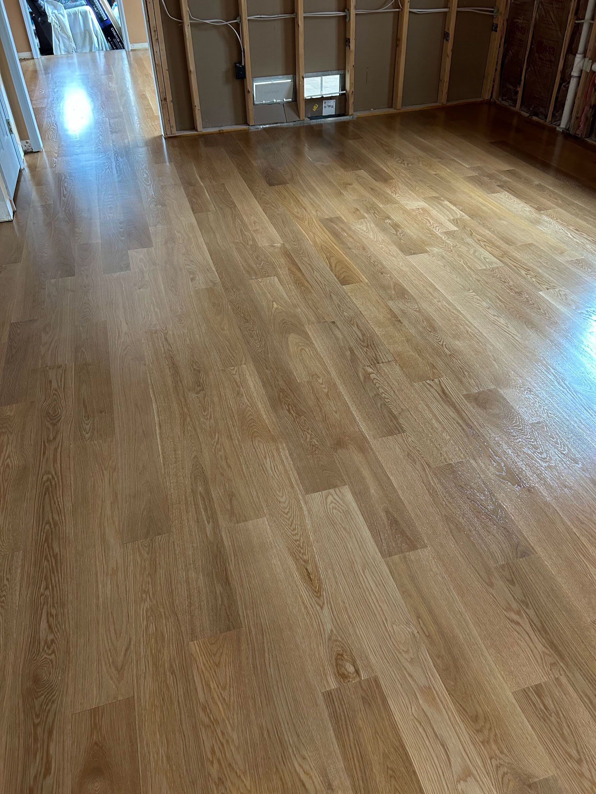 Empty wood-floored room with cardboard boxes against the far wall.