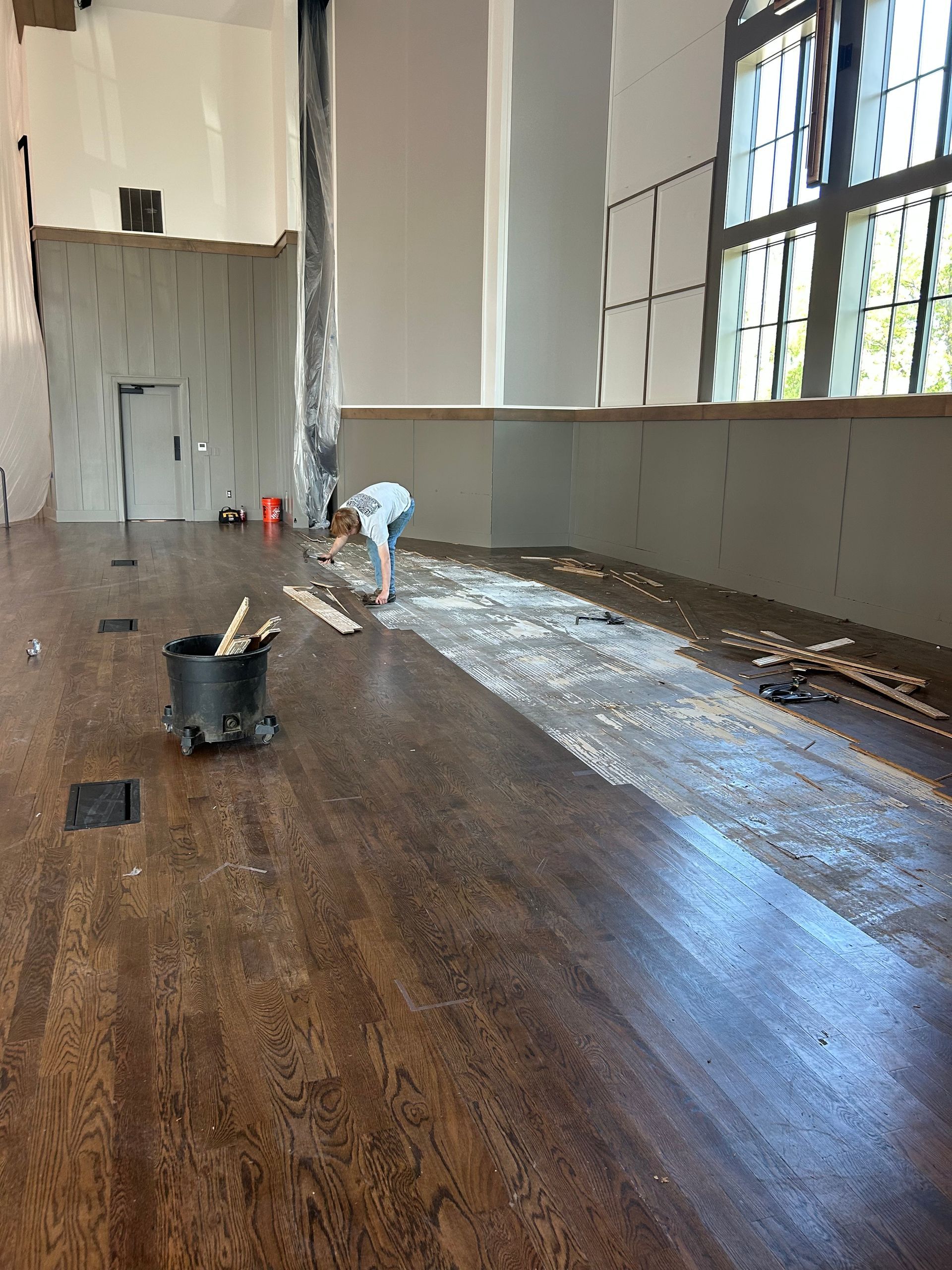 Wood floor partially covered in debris, construction in progress.