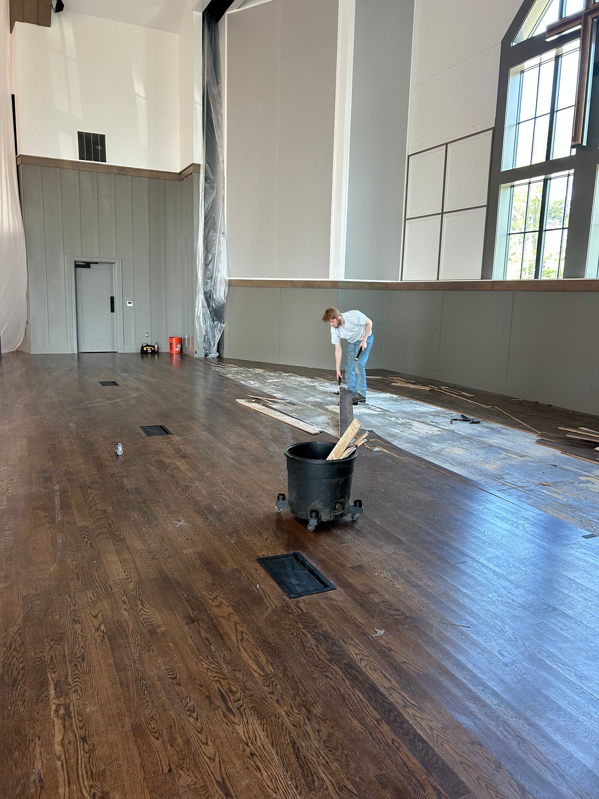 Wood floor partially covered in debris, construction in progress.