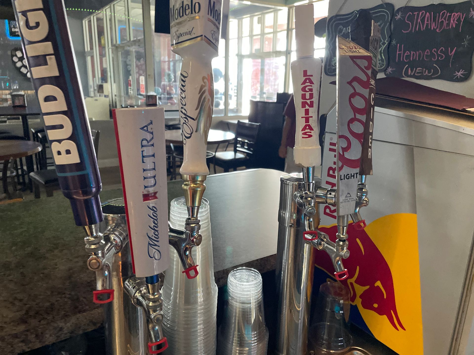A bunch of beer taps are lined up in a restaurant.