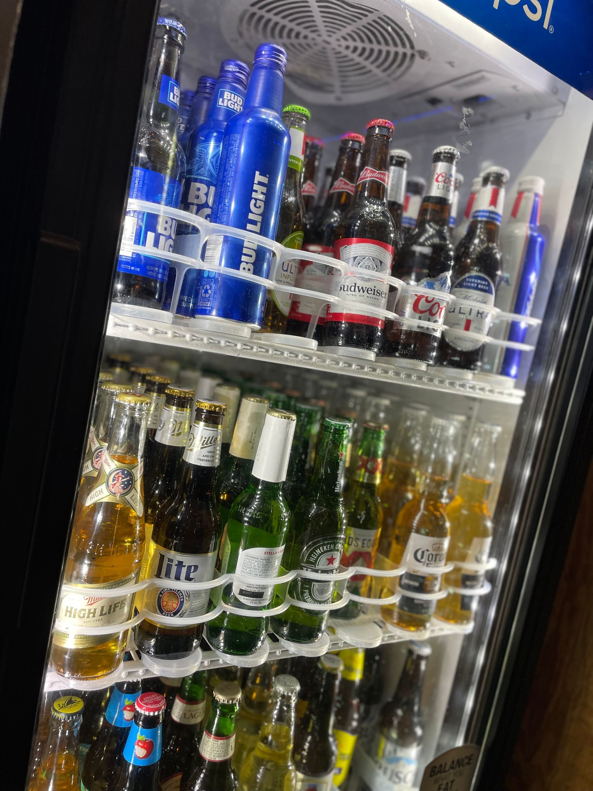 A refrigerator filled with bottles of beer and soda