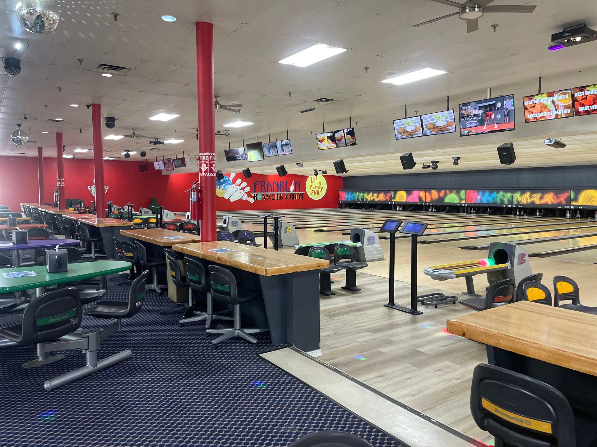 Many tables and chairs in the bowling alley