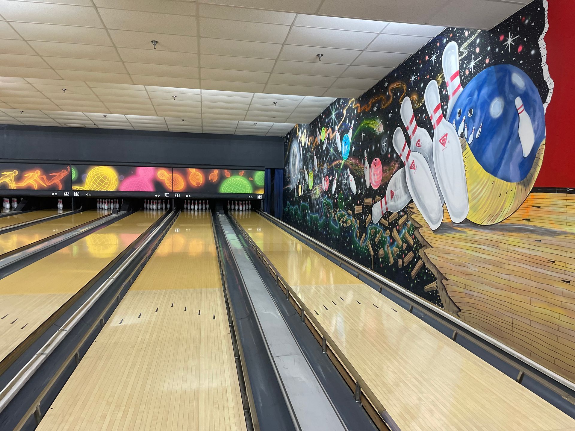 A bowling alley with a large mural on the wall