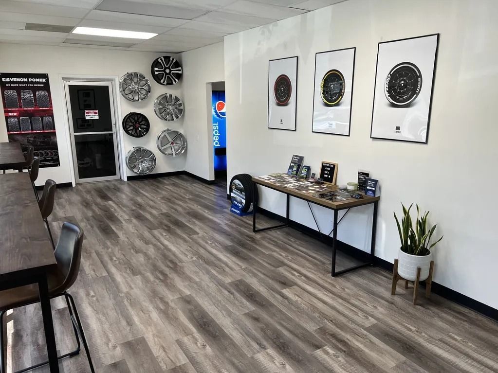 Modern office lobby with wall art, console table, chairs, and wood-look flooring