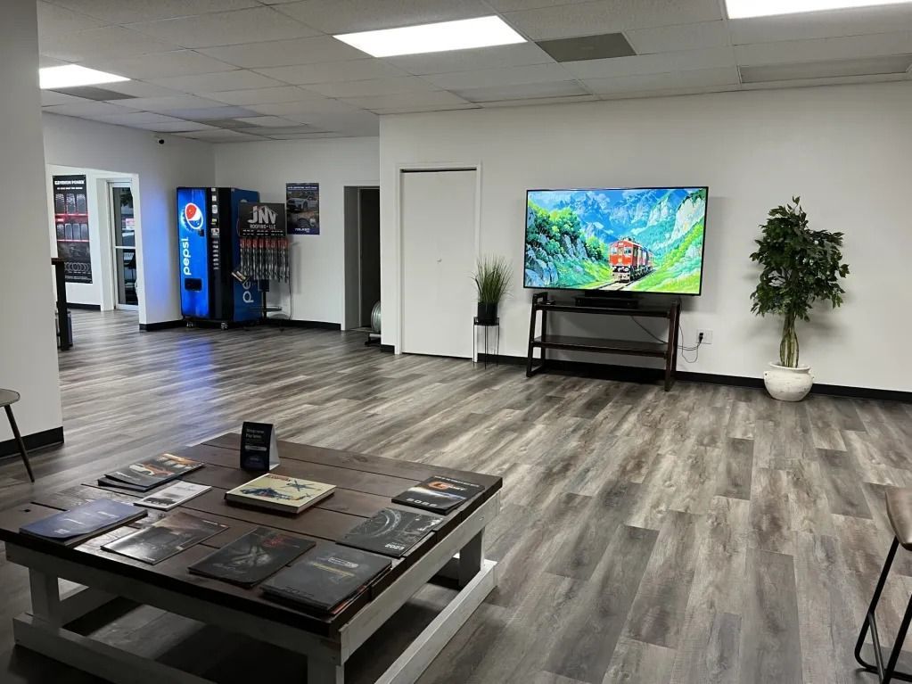 Spacious lobby with seating, vending machines, and a wall-mounted TV showing colorful fish.