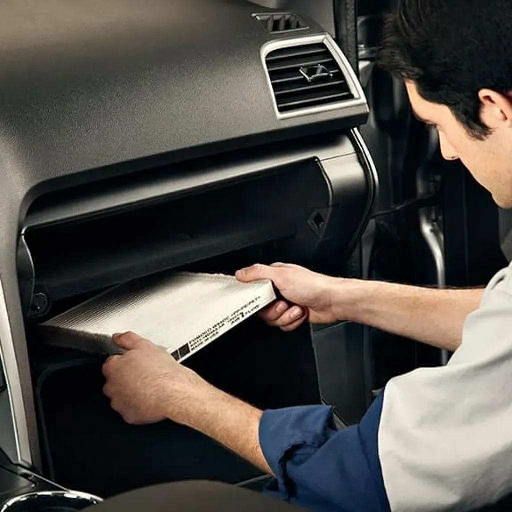Person loading a white notebook into a car glove compartment