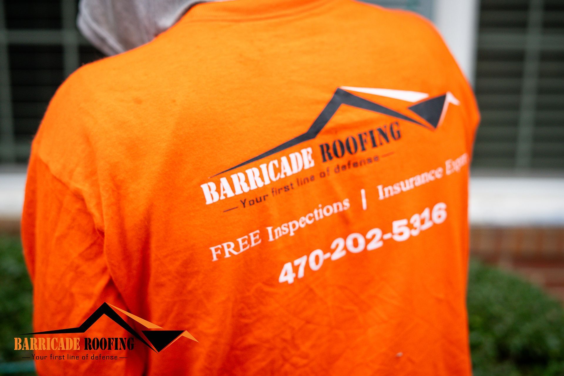 Orange shirt with Barricade Roofing logo and phone number, viewed from behind.