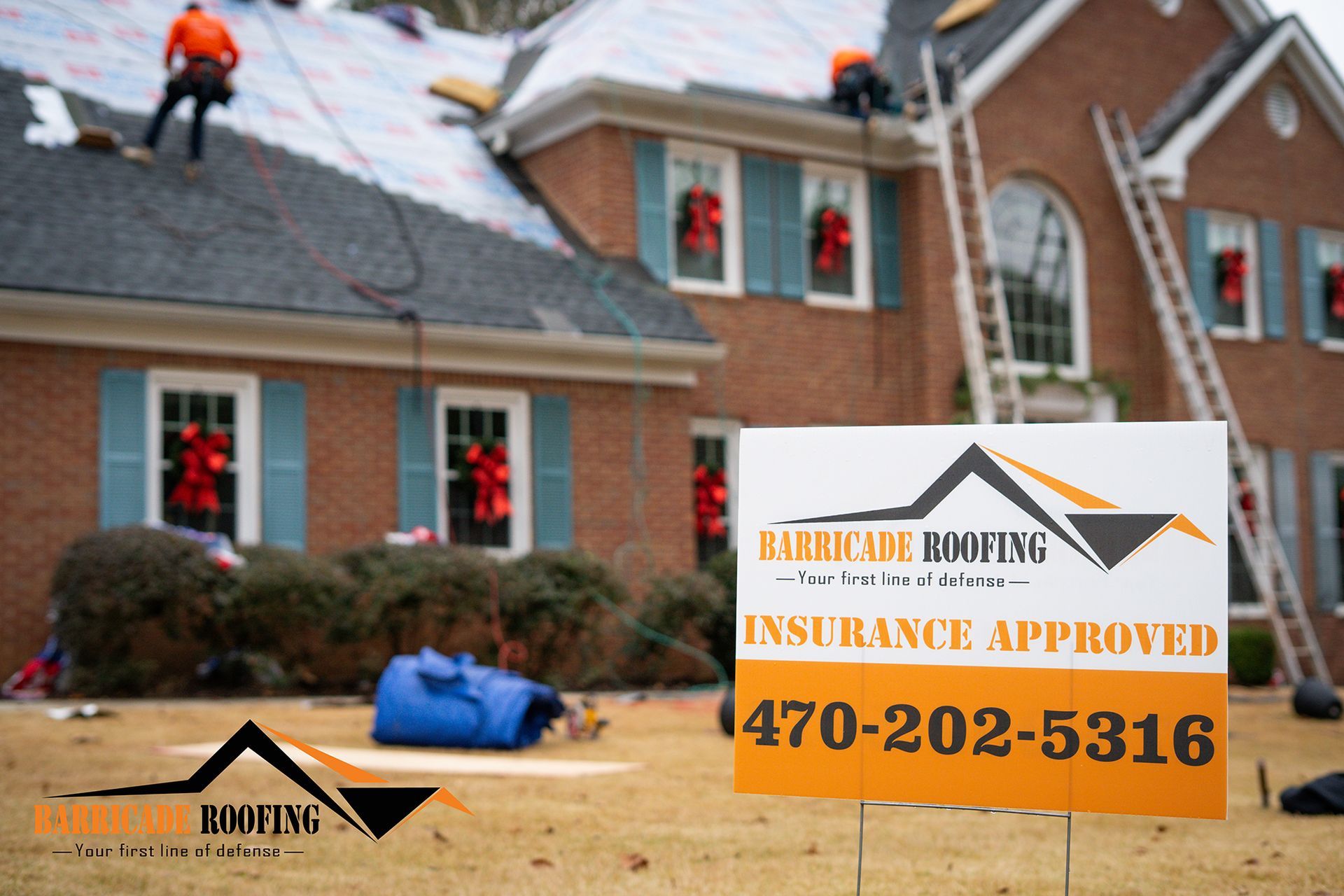 Roofers working on a house, sign for Barricade Roofing.