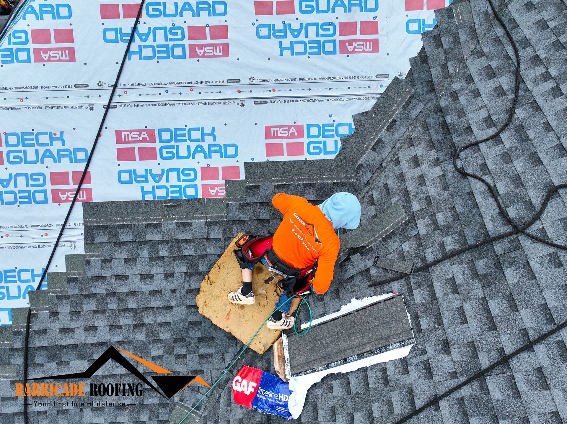 Roofer on a sloped roof installing shingles, secured by safety lines. White, blue, and orange colors.