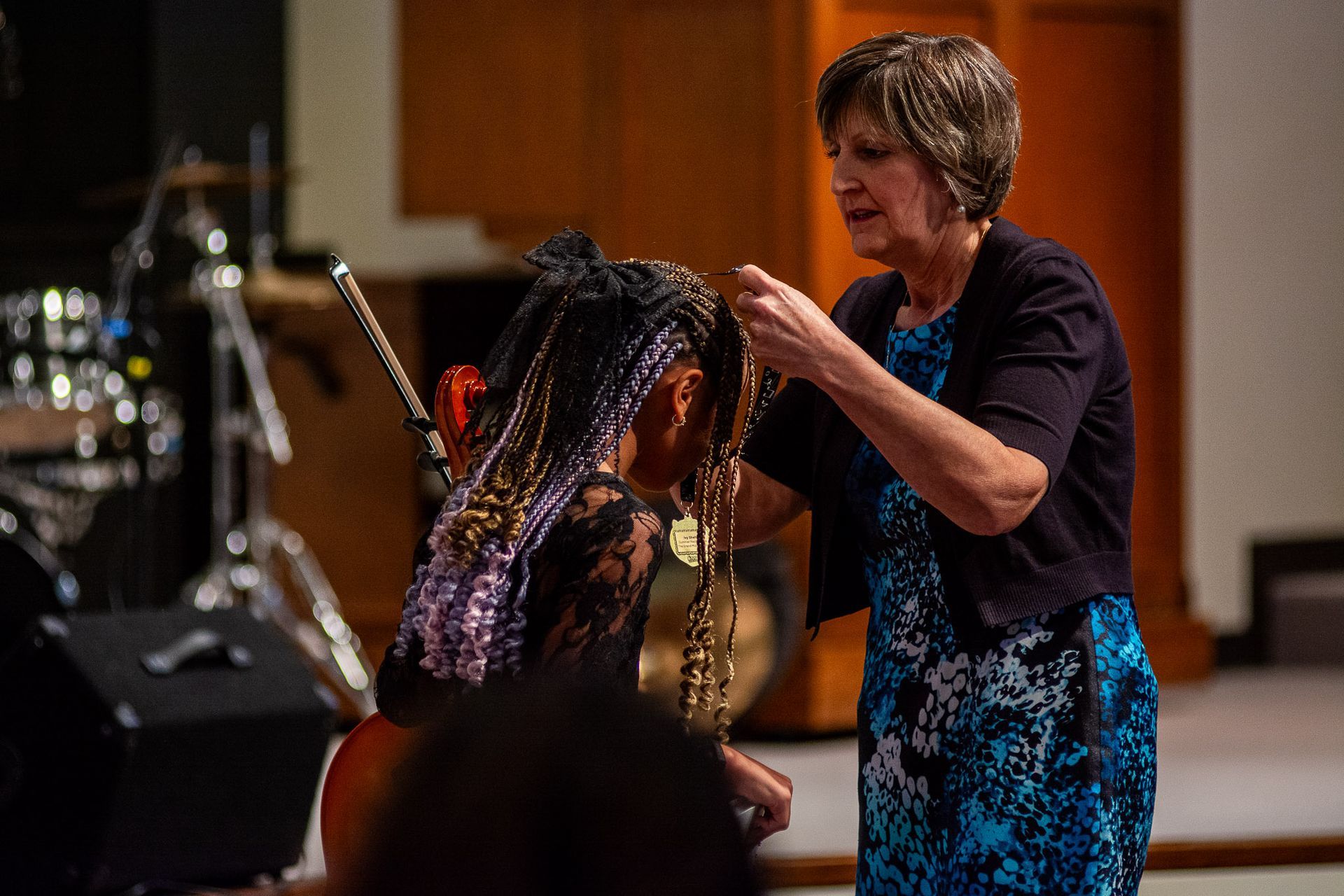 A woman is braiding a girl 's hair in a church.