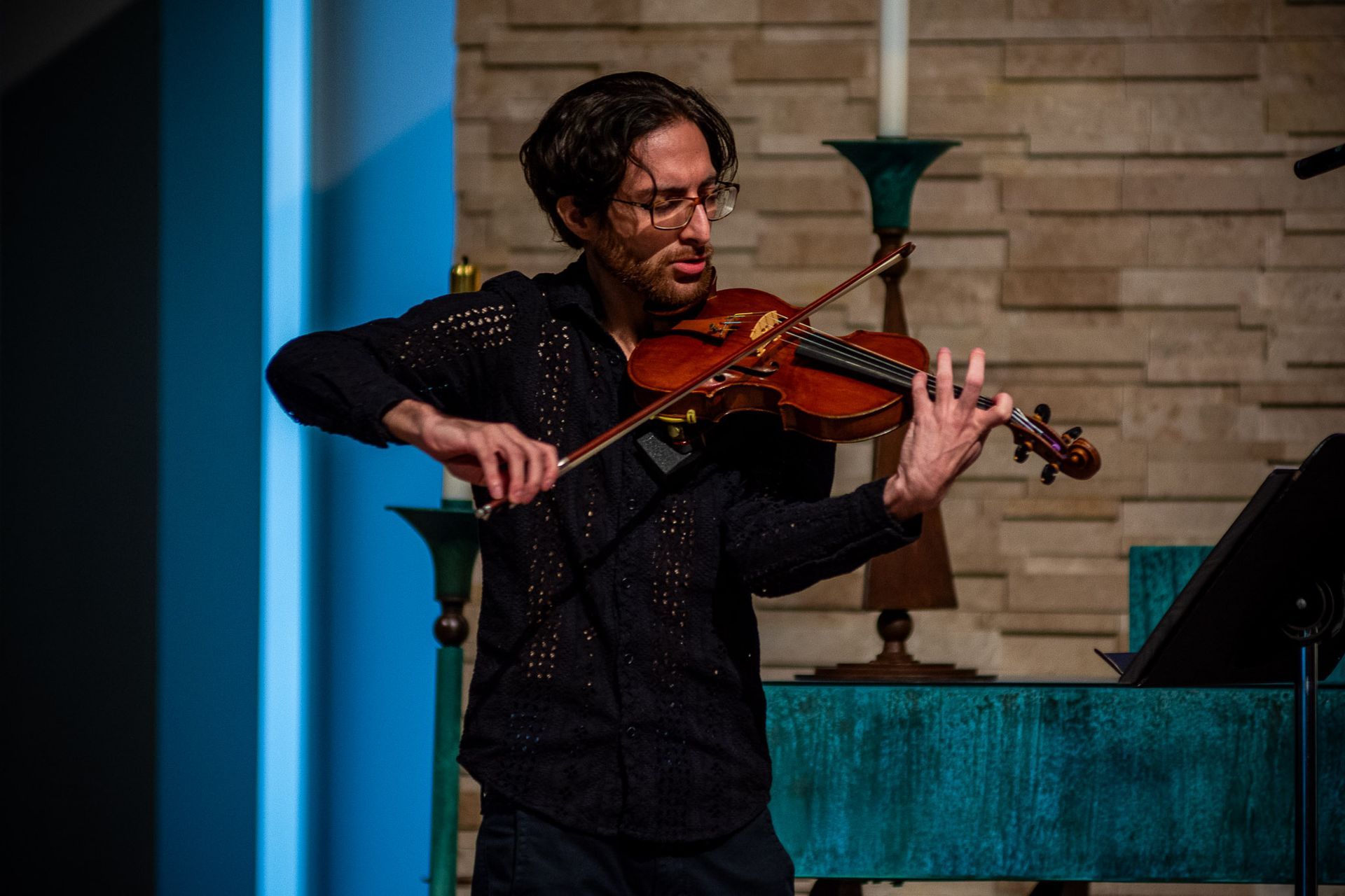 A man is playing a violin in a church.
