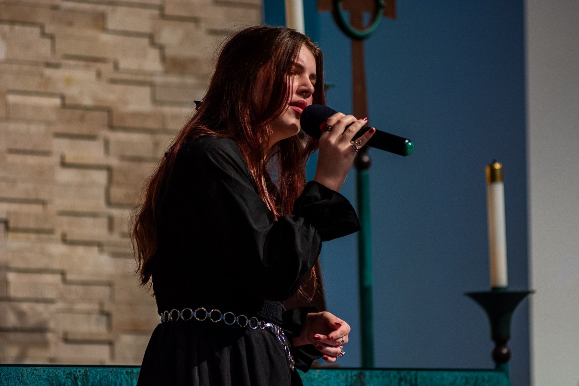 A woman is singing into a microphone in a church.