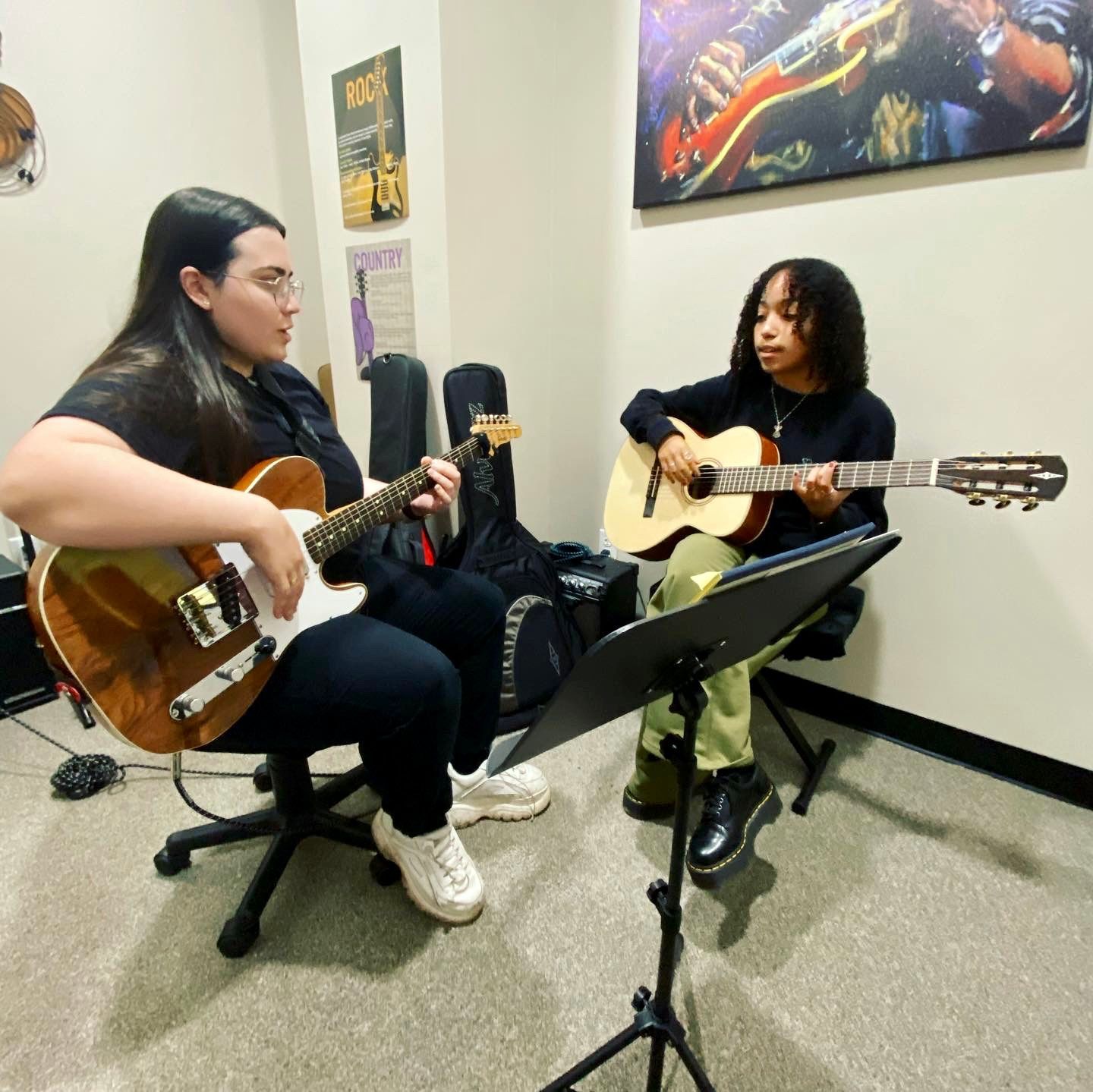 A woman and a child are playing guitars in a room