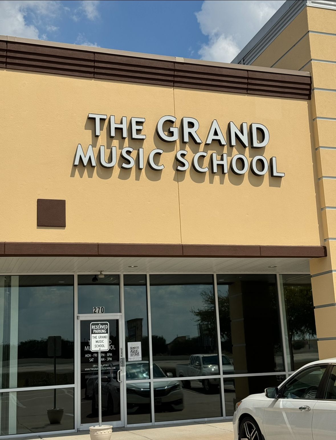 A car is parked in front of the grand music school