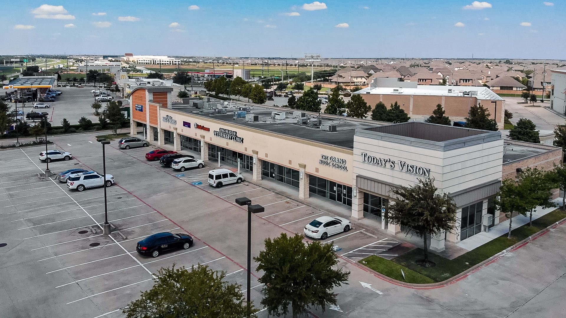An aerial view of a shopping center with cars parked in front of it.