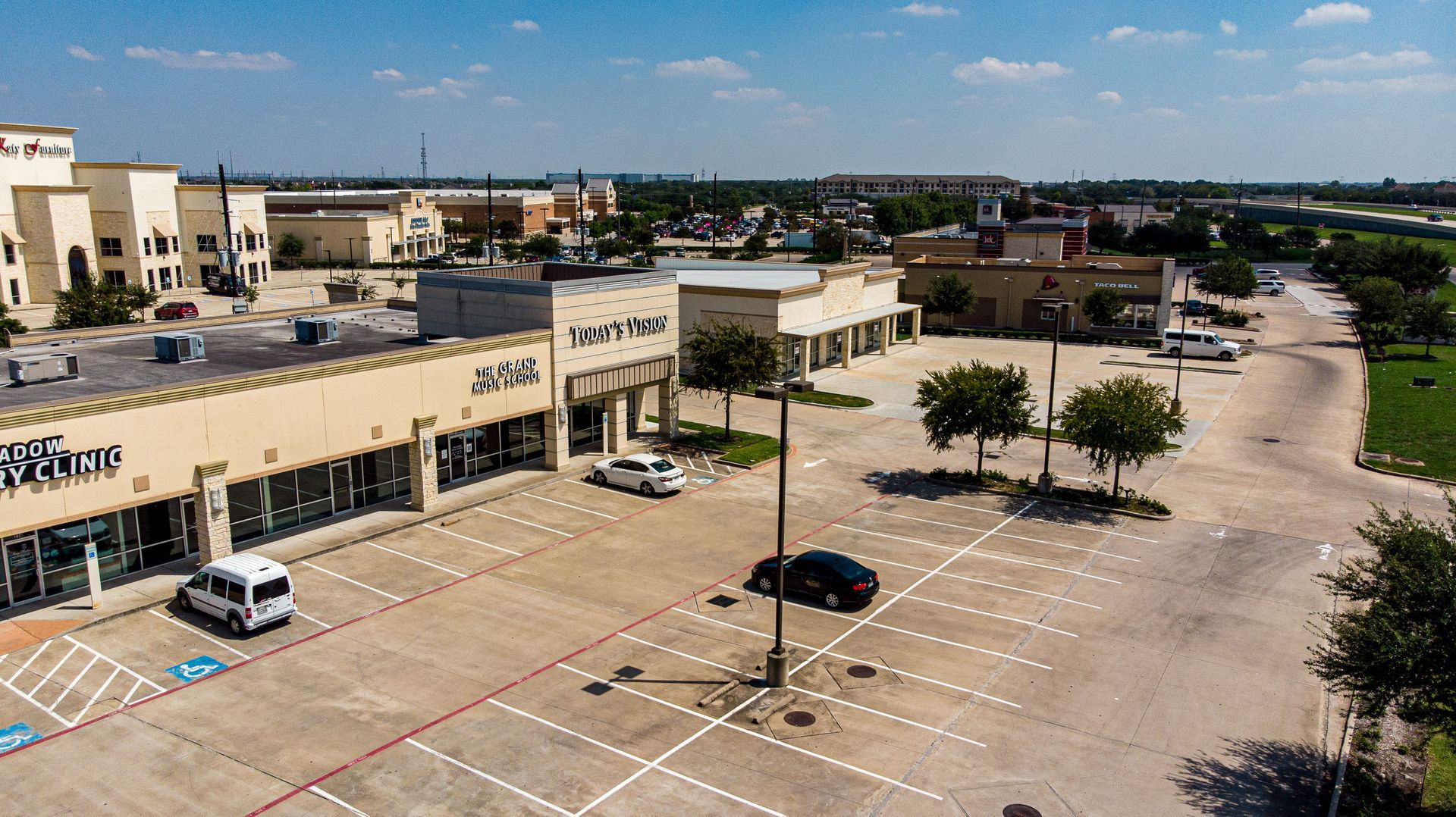 An aerial view of a parking lot in front of a shopping center.