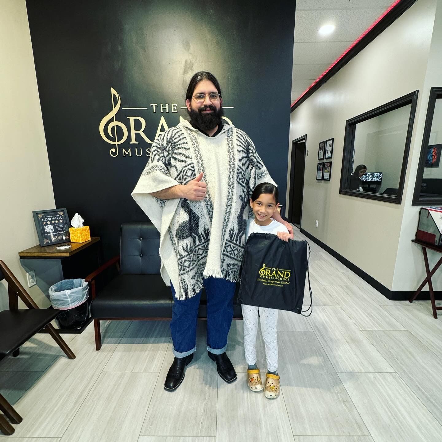 A man and a little girl are posing for a picture in a waiting room.