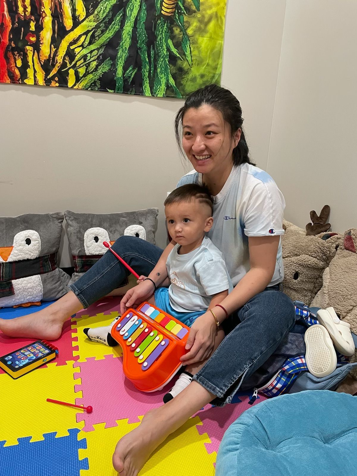 A woman is sitting on the floor with a child.