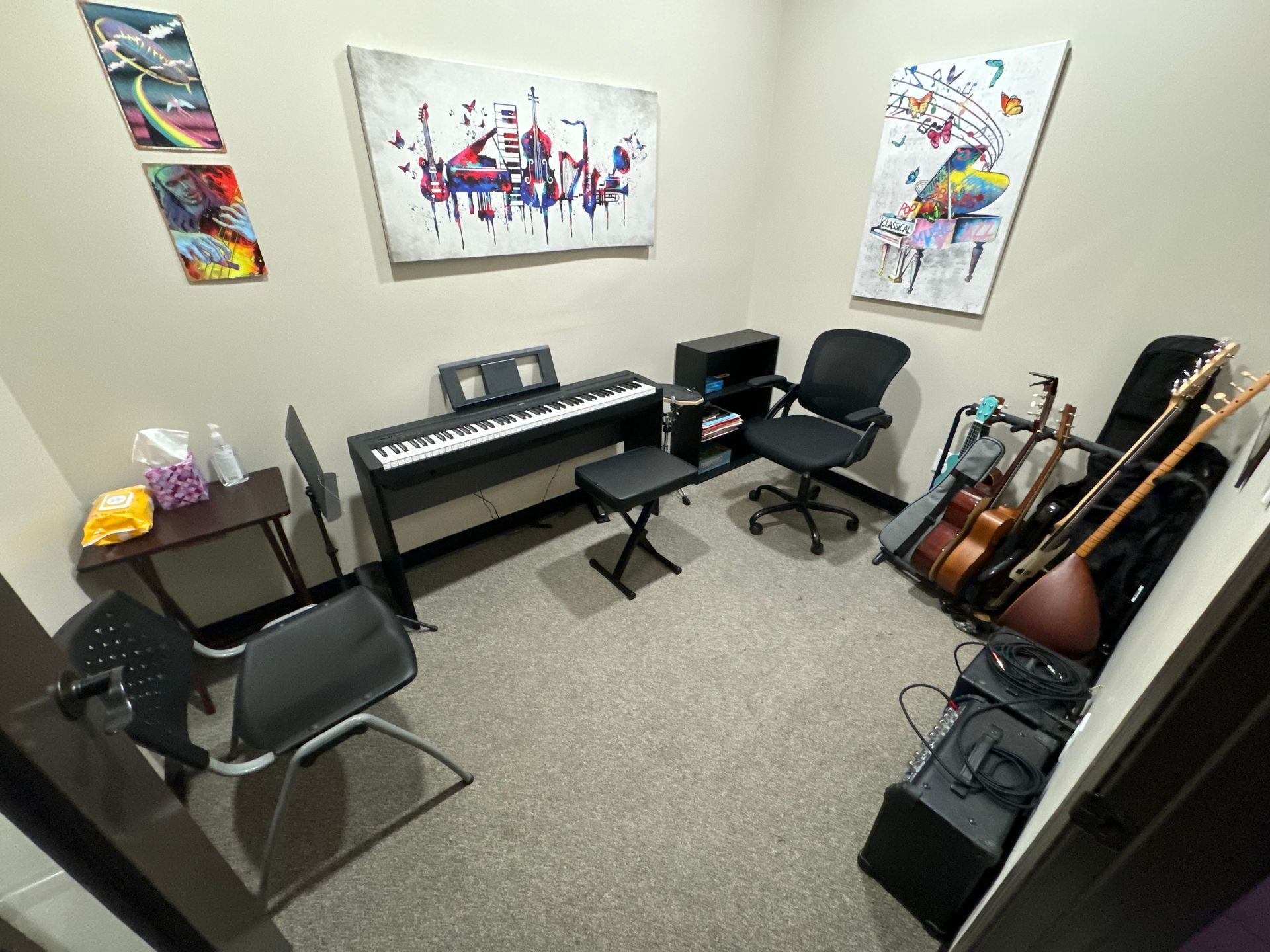 A room with a piano , chairs , guitars , and a painting on the wall.