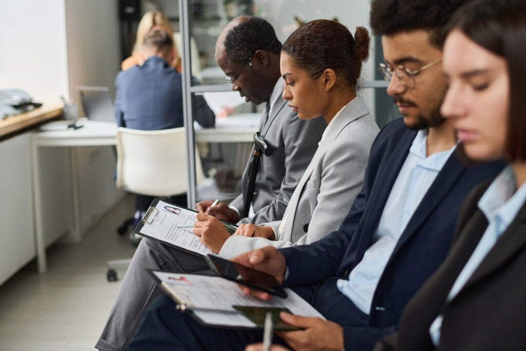 A group of people are sitting in a row at a job interview.