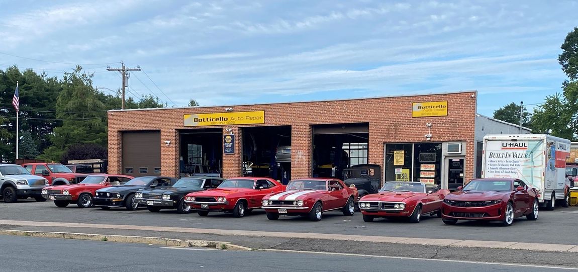 Multiple Classic Cars in front of a brick building