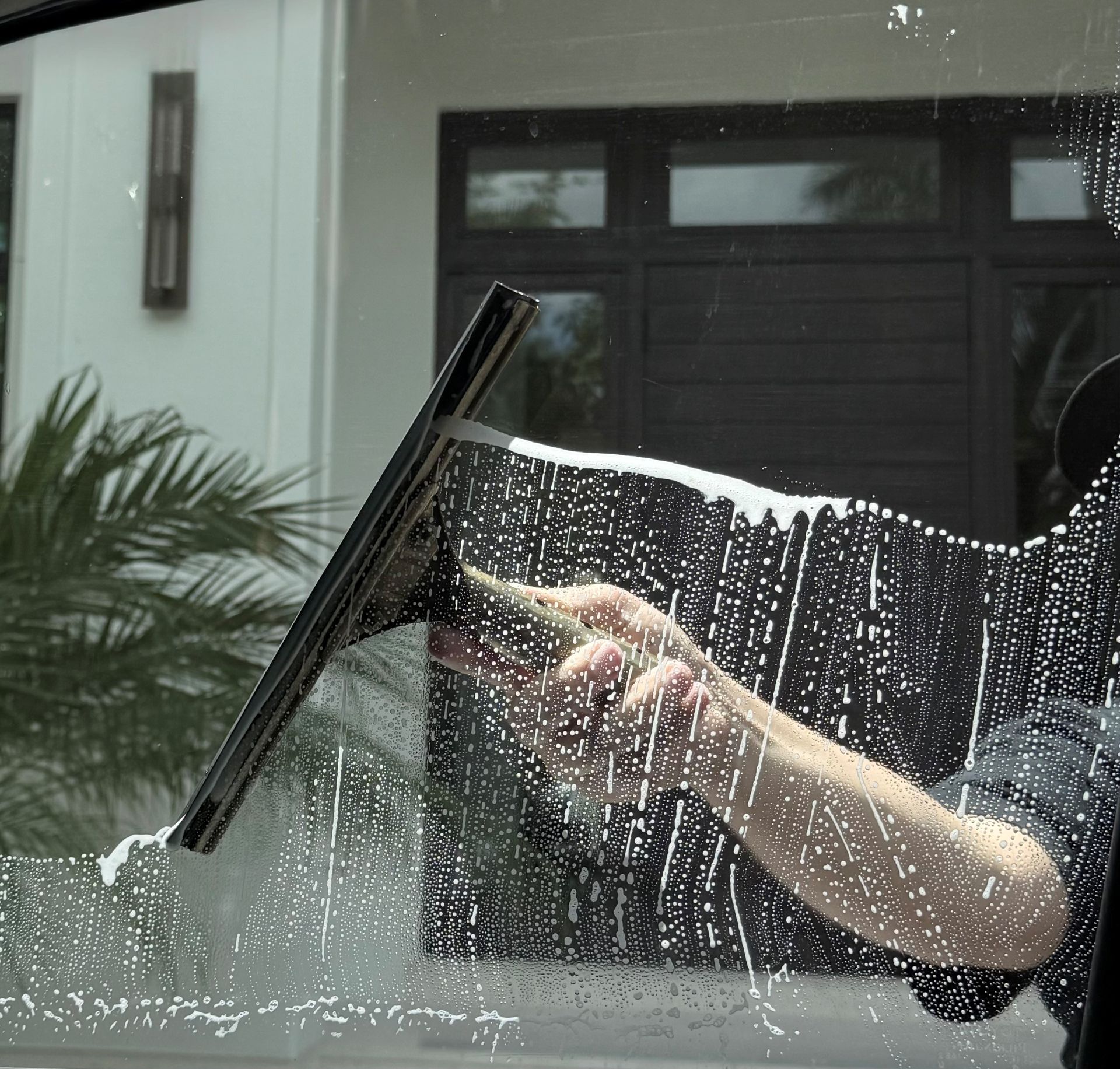 Person cleaning a window with a squeegee