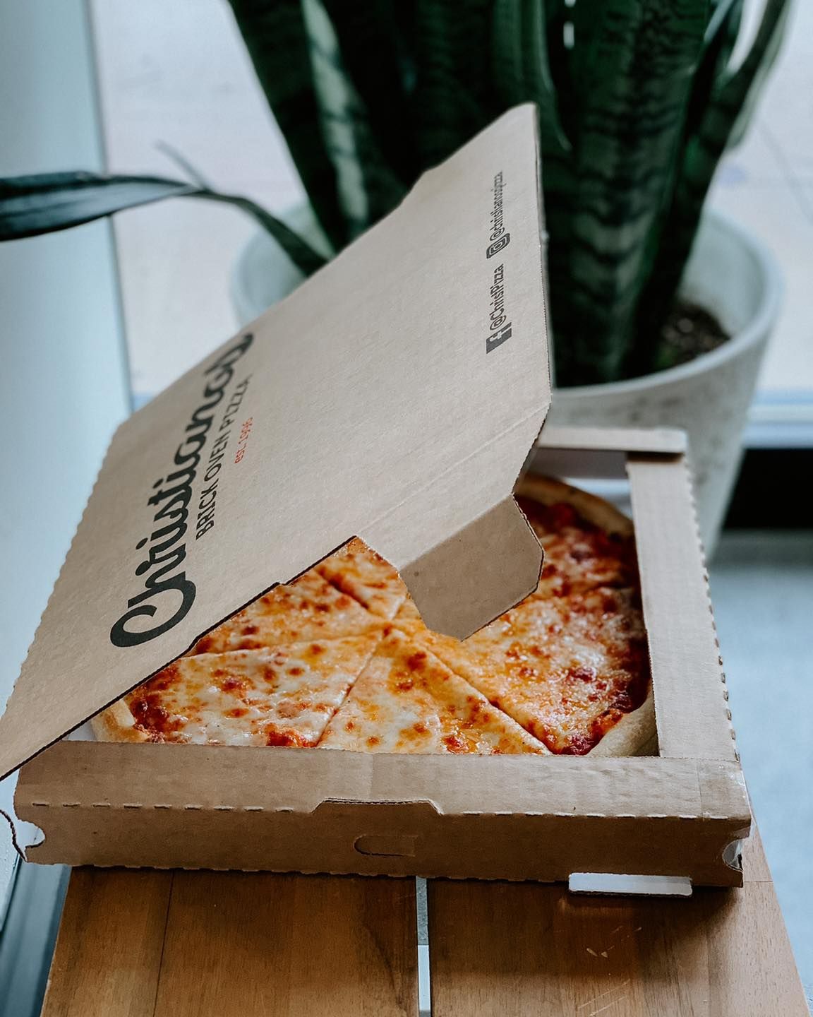 A pizza in a cardboard box with the lid open