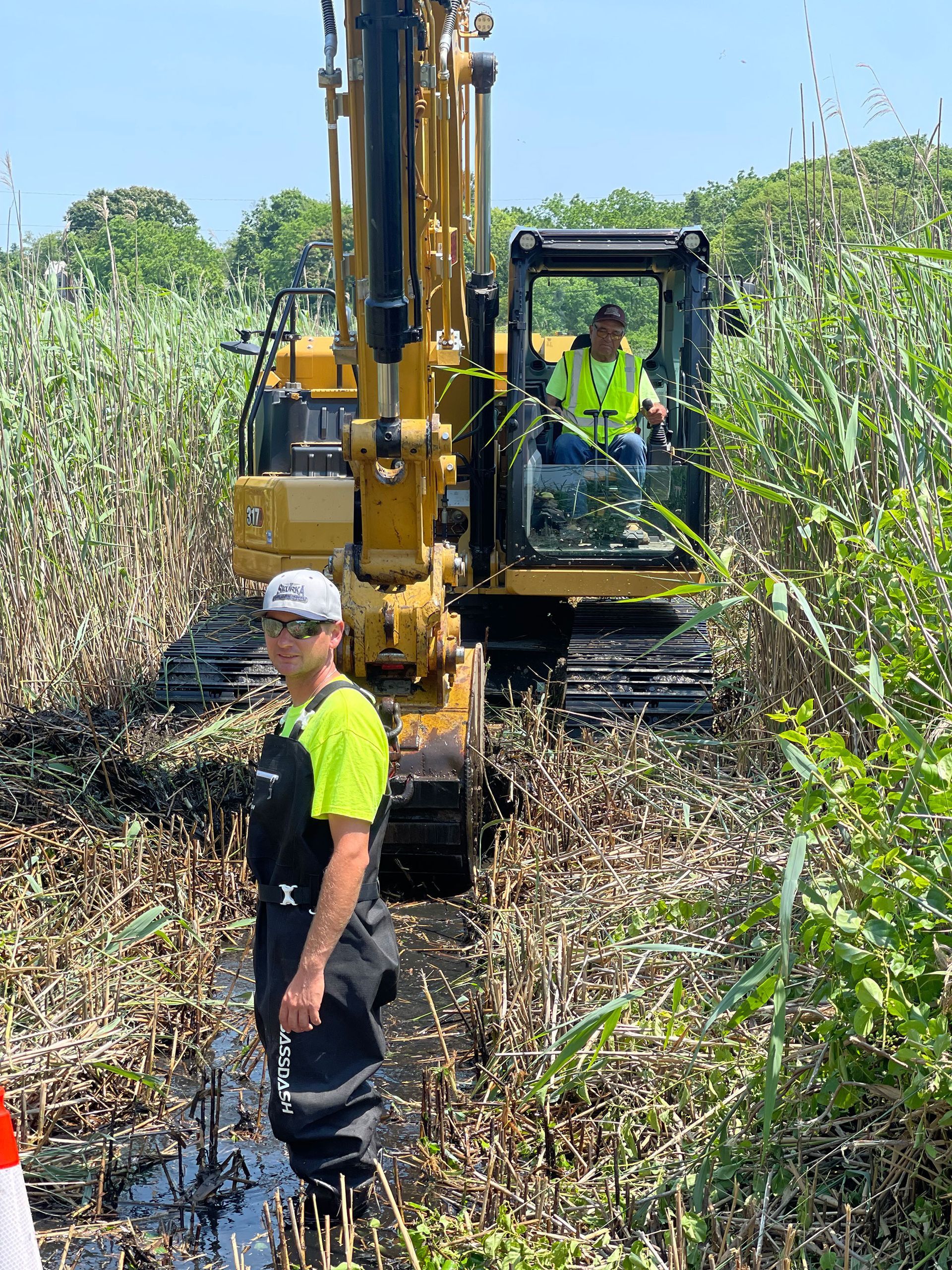 A man is standing in front of a bulldozer in a field.