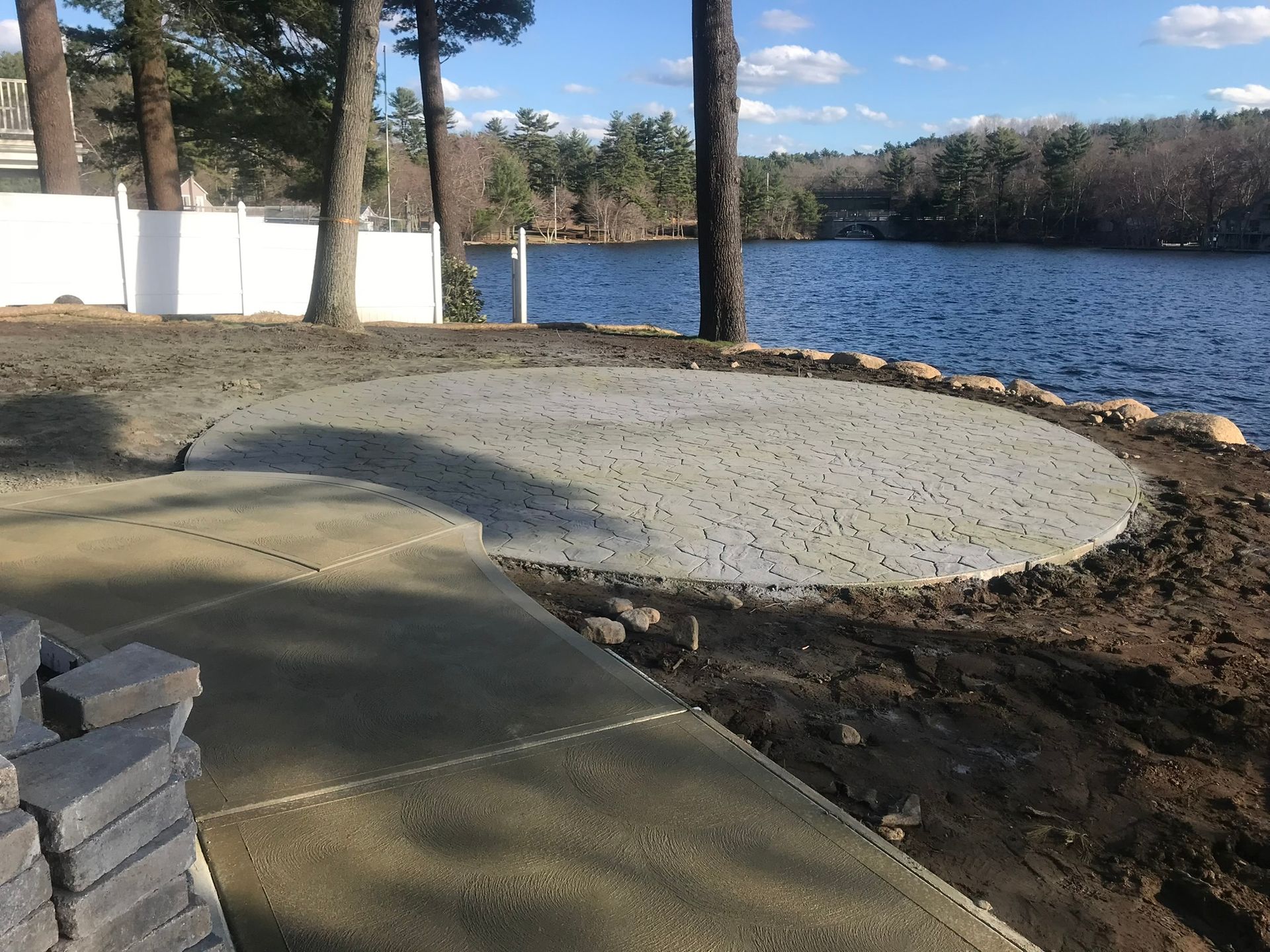 A patio is being built on the shore of a lake