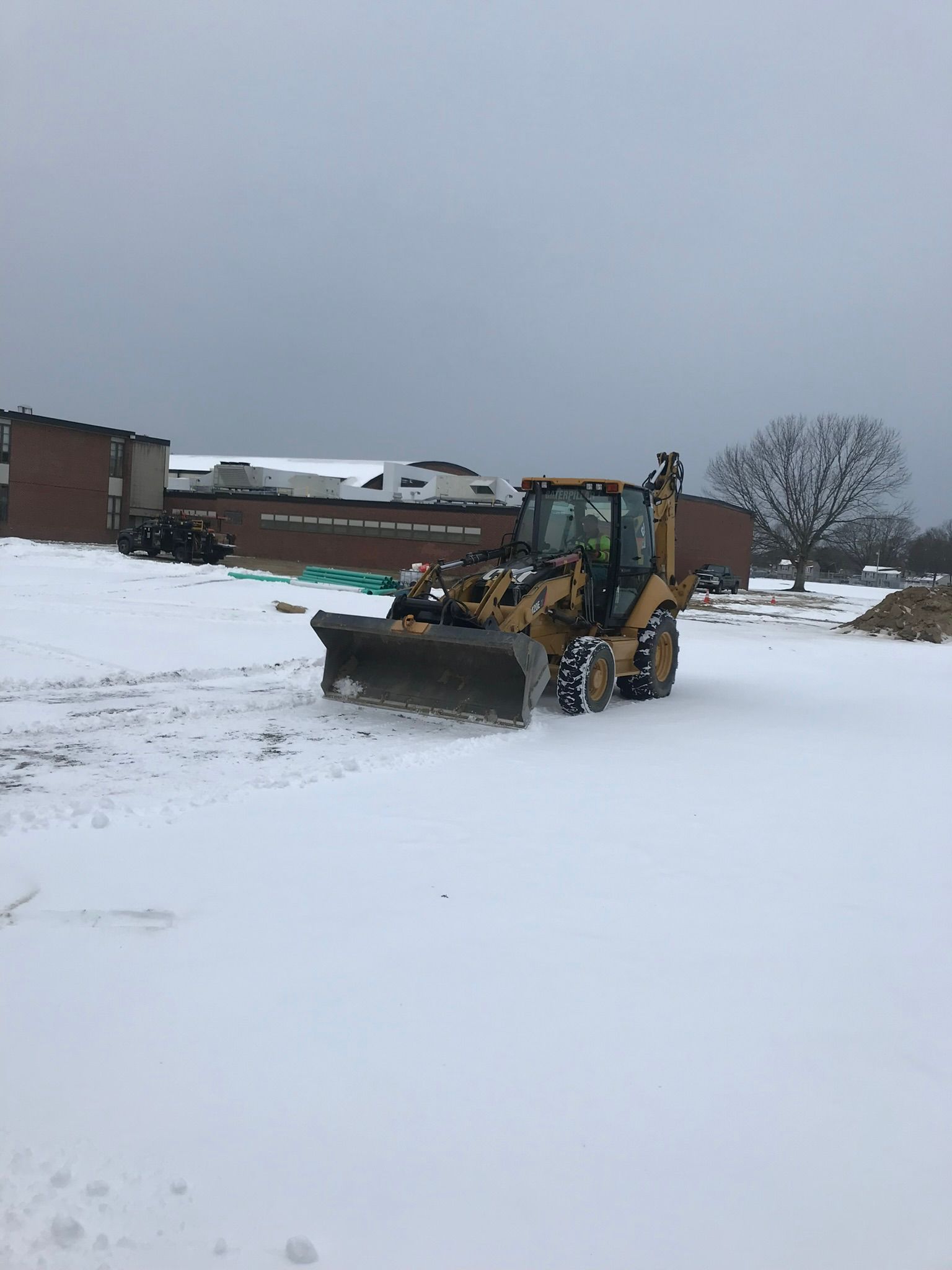 A bulldozer is driving through a snowy field