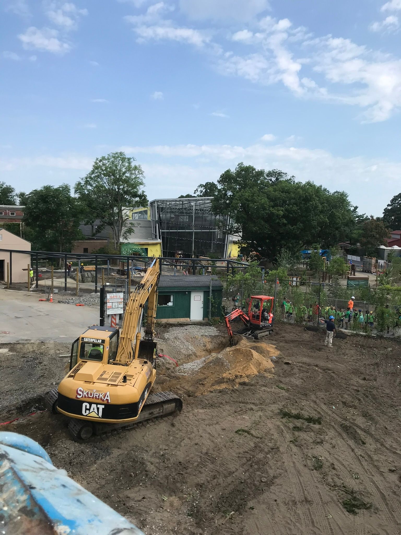 A large yellow excavator is sitting in the middle of a dirt field
