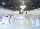 Elegant banquet hall with white-covered tables and chairs under chandeliers