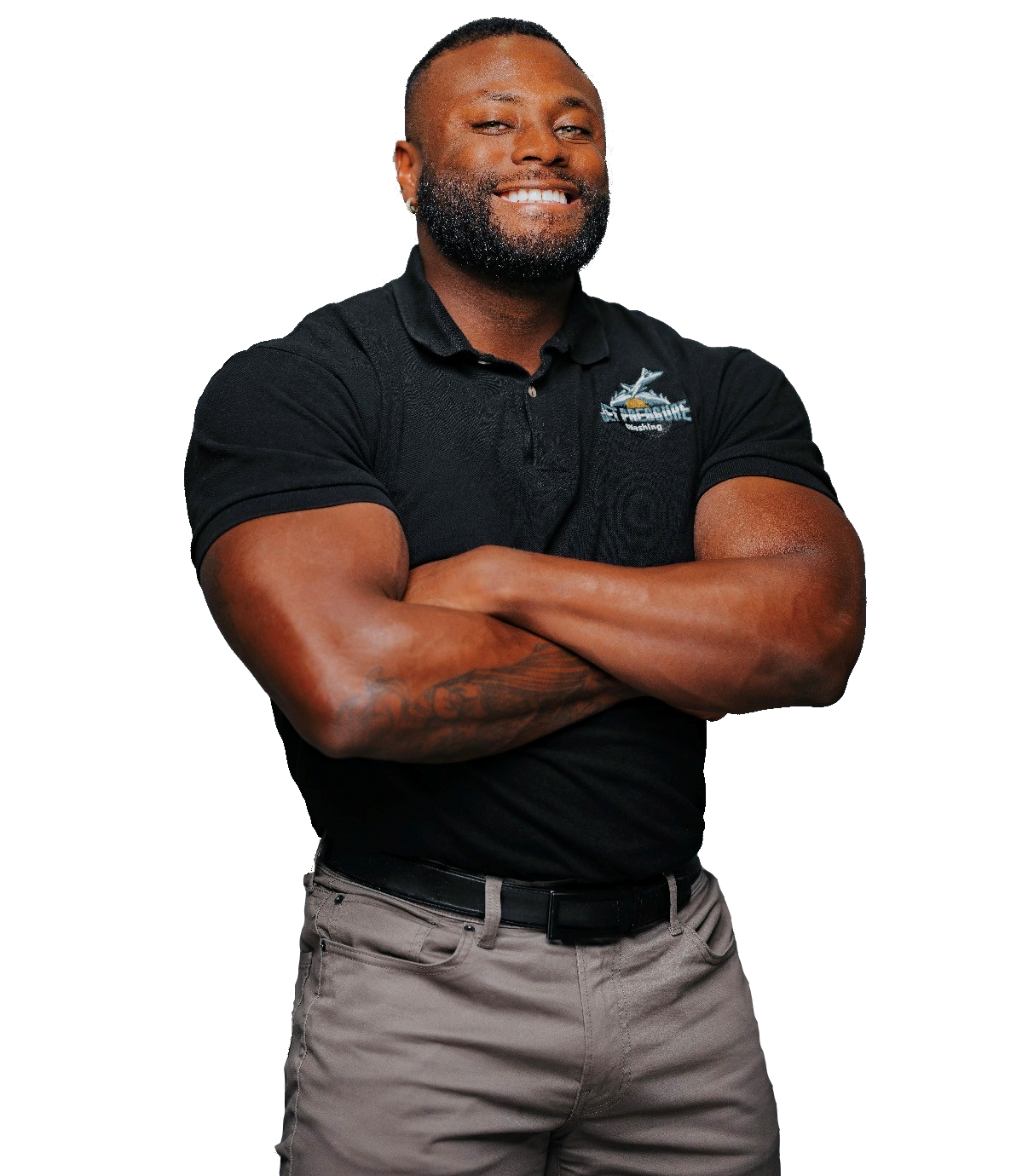A person smiling with arms crossed, wearing a black polo shirt and grey pants against a plain white background.