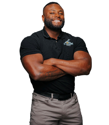A person smiling with arms crossed, wearing a black polo shirt and grey pants against a plain white background.
