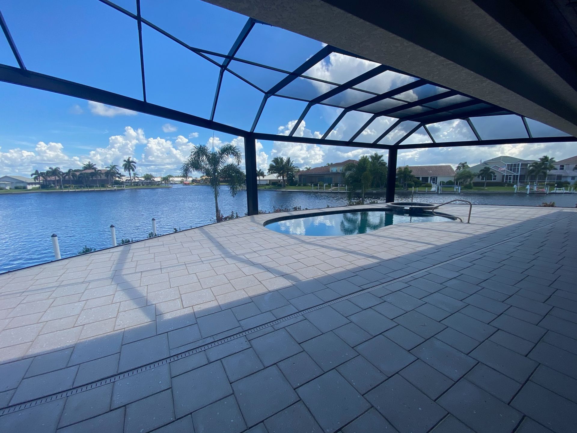 A patio with a pool and a view of a lake