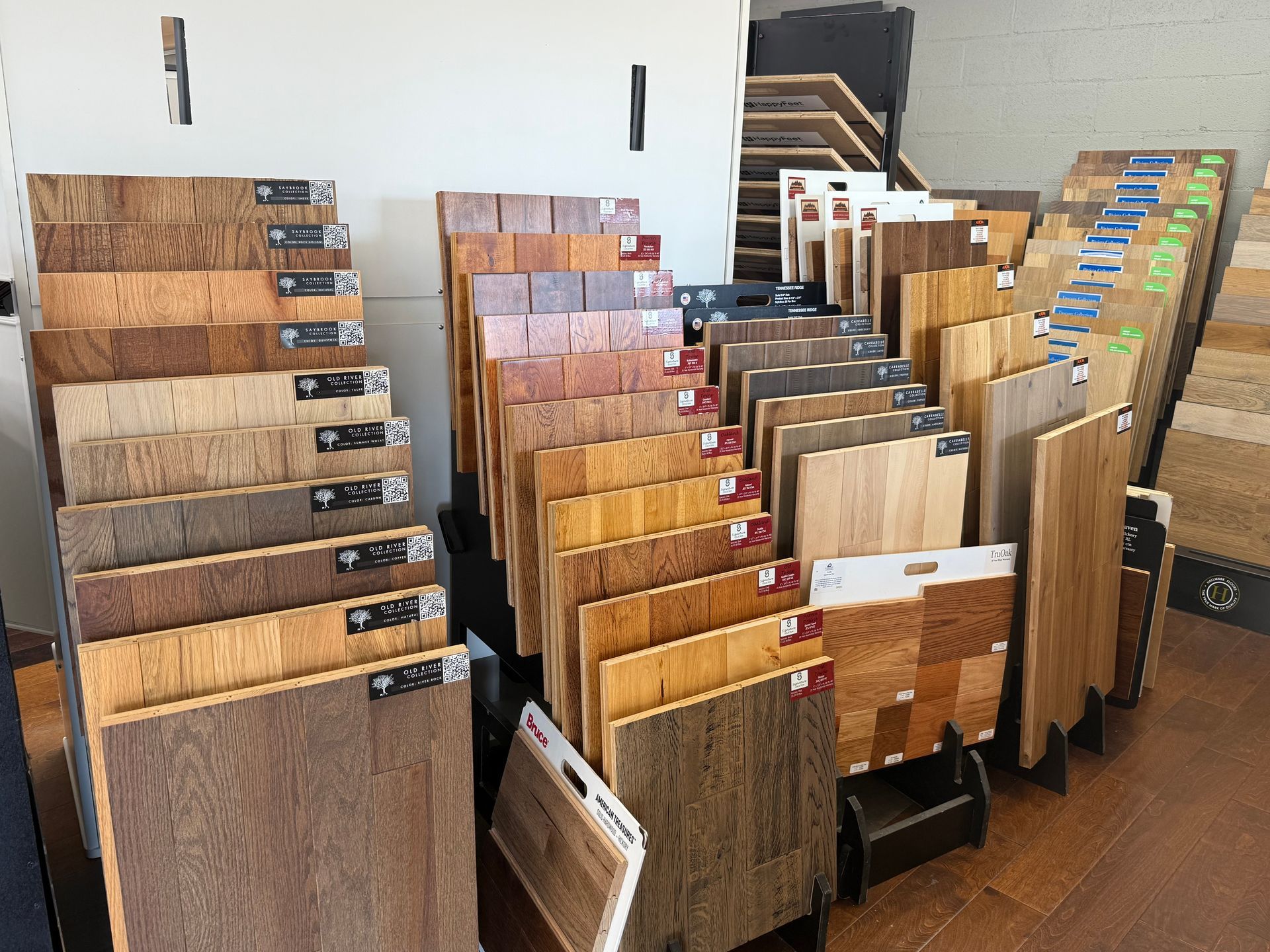 Displays of various wood flooring samples in a showroom; light to dark shades of wood.