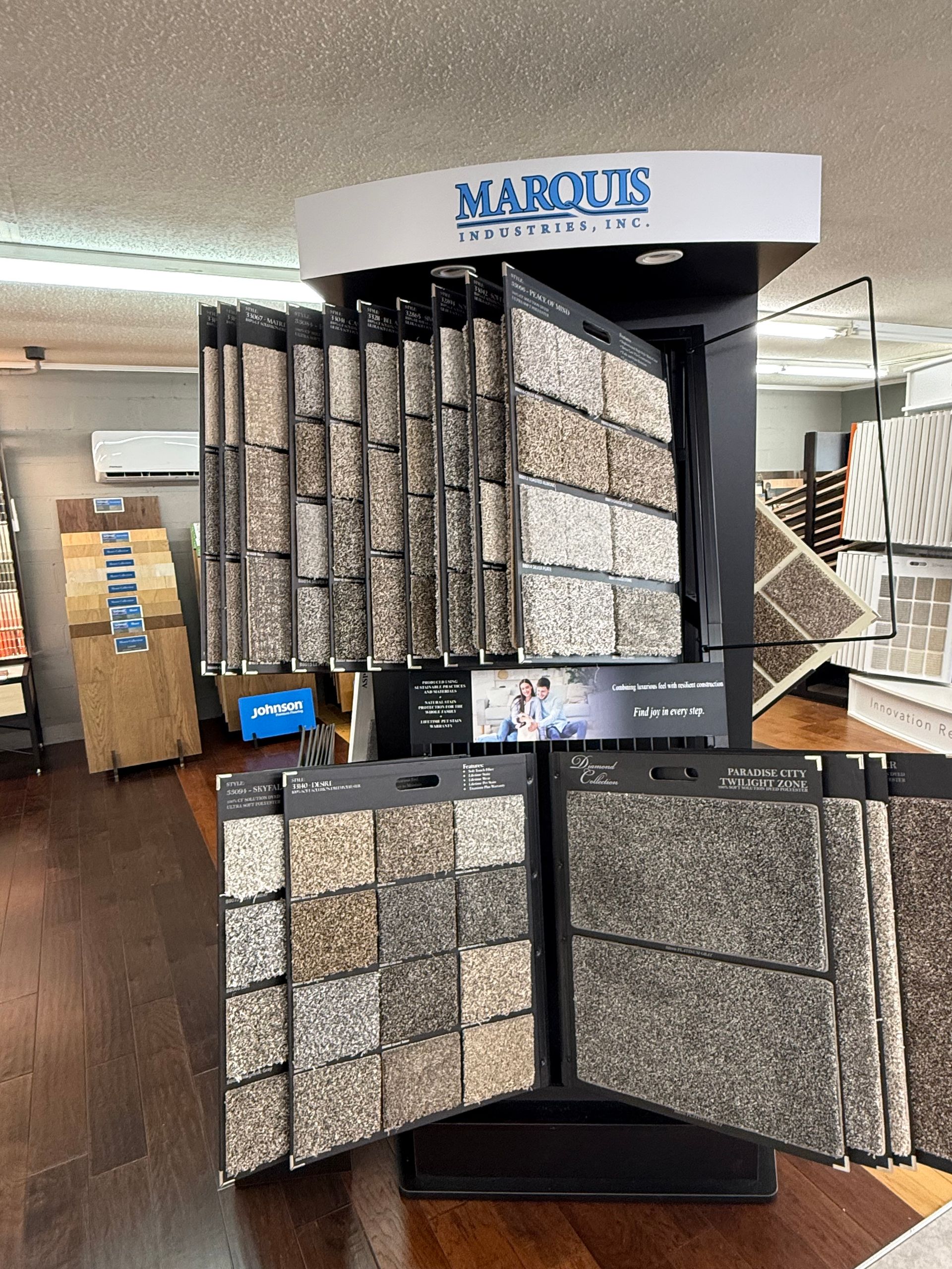 Carpet sample display stand in a store, showing various colors and textures.