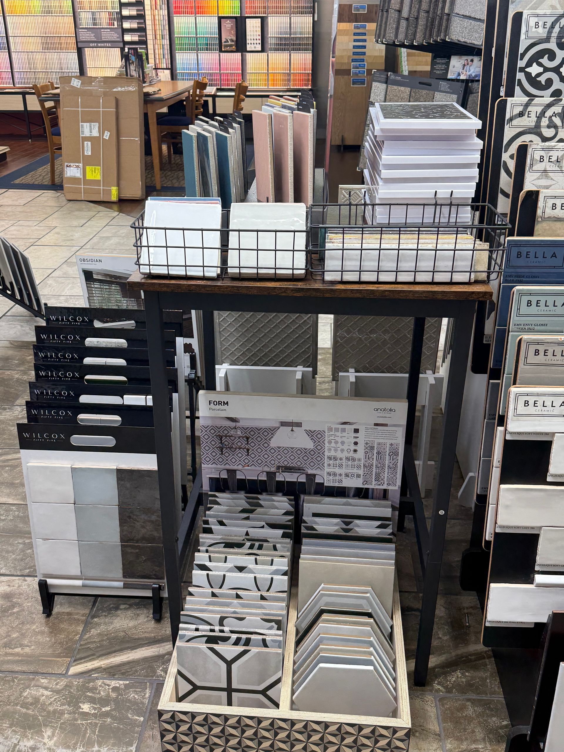 Tile samples displayed on a store rack, featuring various colors and patterns.