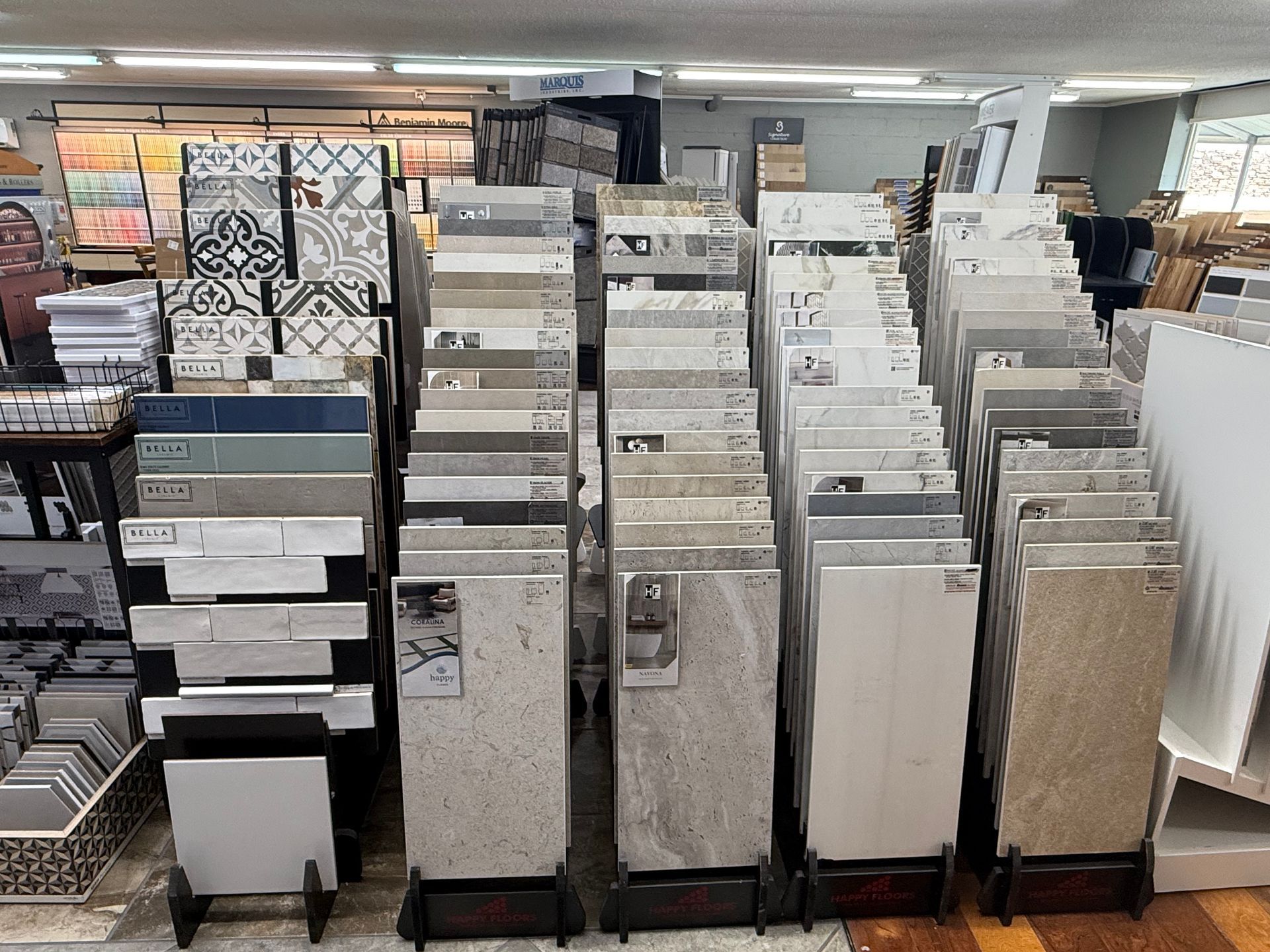 Tile displays in a store showcase various colors, patterns, and textures for flooring and walls.
