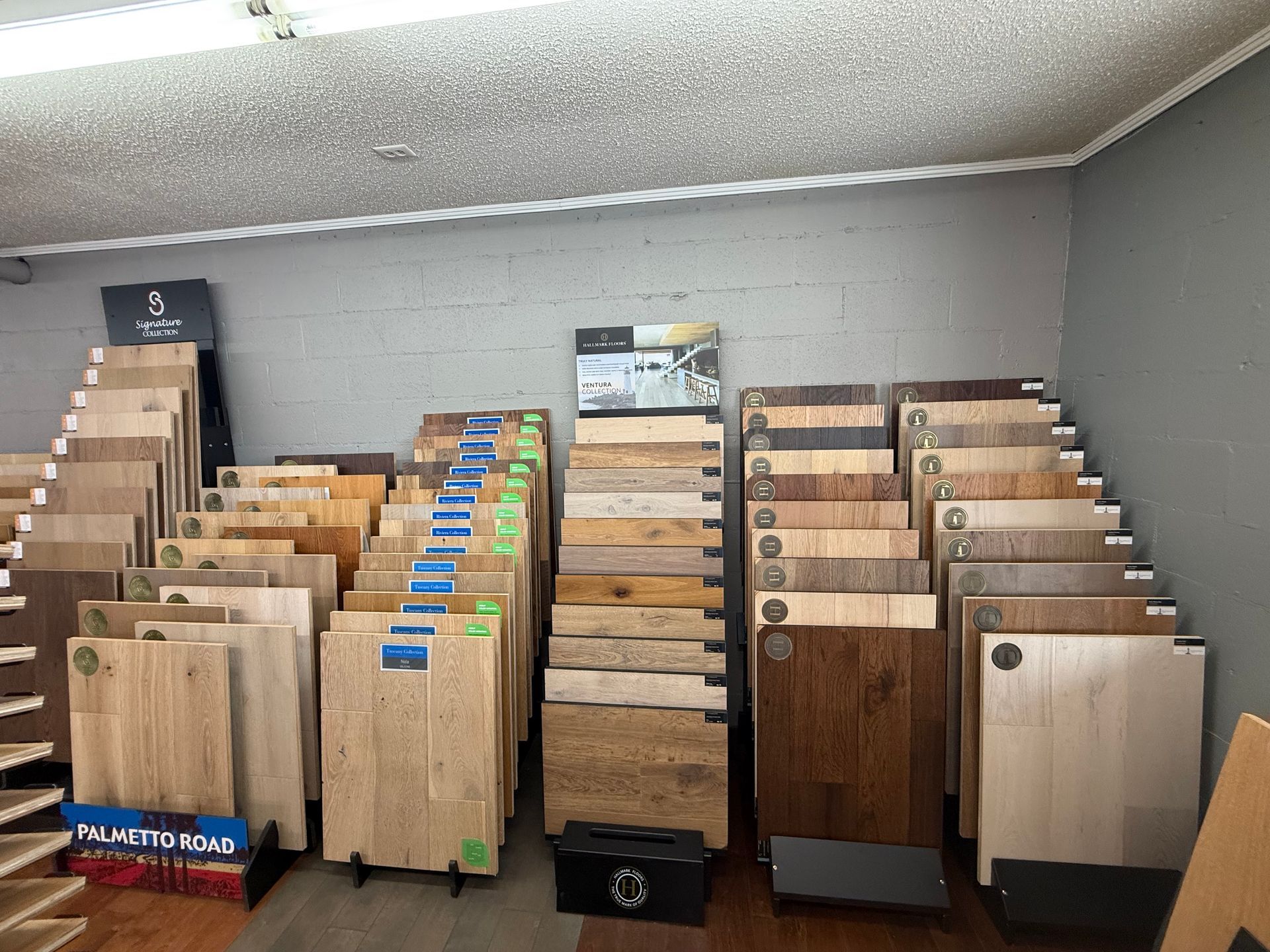 Display of various wood flooring samples in a showroom; light and dark wood colors.