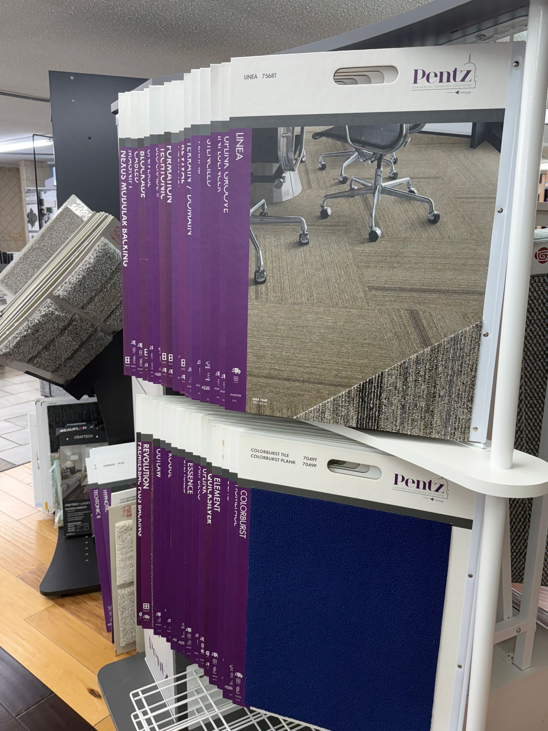 Carpet samples on display, with various colors and textures. Purple and blue are prominent.
