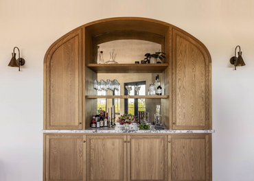 A wooden cabinet with a bar inside of it.